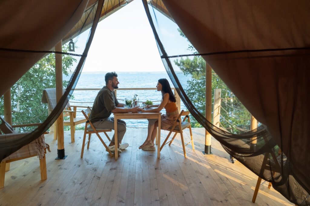 Young romantic couple enjoying breakfast on terrace by seaside