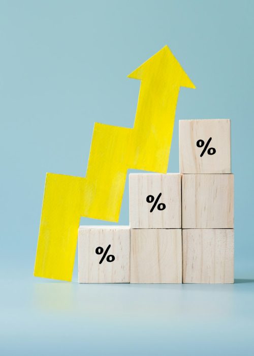 Yellow paper cut arrow going up positive trend on wooden blocks with percentages